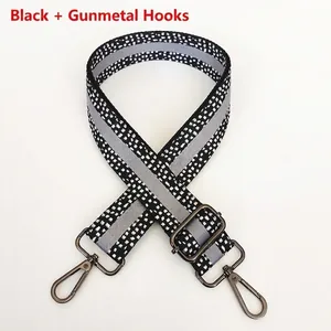 Detail of adjustable black and white spotted strap with grey stripe and gunmetal hooks