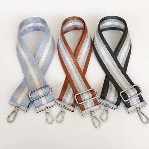Close-up of three adjustable striped bag straps with silver glitter and metal hooks