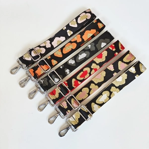Close-up of adjustable leopard print shoulder straps with metallic thread and silver hooks