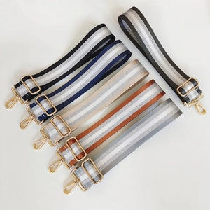 Detail view of multi-colored adjustable striped bag straps with gold metal hooks