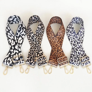 Detail view of four leopard print wide bag straps with adjustable gold hardware buckles