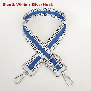 Detail of adjustable blue and white striped woven bag strap with silver metal hooks