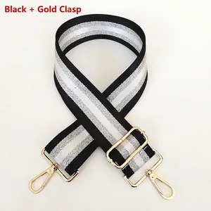 Detail of adjustable black and silver striped bag strap with gold metal hooks