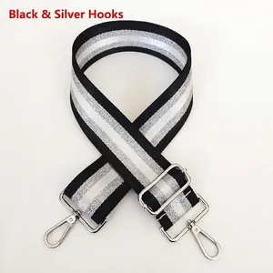 Detail of adjustable black and silver striped bag strap with metallic lobster clasps