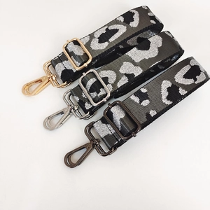 Close-up of leopard print shoulder straps with gold, silver and gunmetal hardware clasps