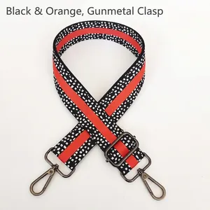 Detail of adjustable nylon bag strap in orange and black pattern with gunmetal swivel hooks