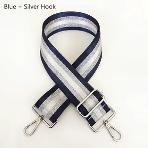 Close-up of adjustable striped bag strap with silver metal hooks and buckle detail
