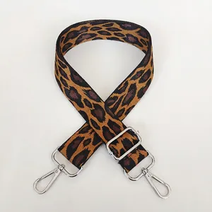 Detail of leopard print woven strap with silver swivel hooks and adjustable buckle