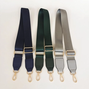 Detail view of high density nylon bag straps with leather trim and gold metal lobster hooks