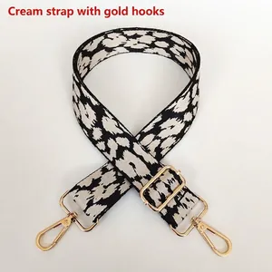 Adjustable leopard print canvas bag strap with cream white patterns and gold metal hooks