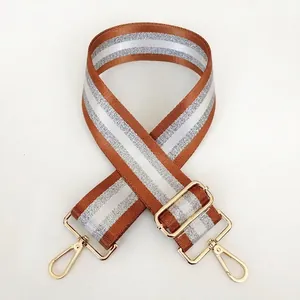 Adjustable brown striped bag strap with gold metal hooks and durable nylon weaving
