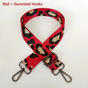 Detail of red leopard print wide bag strap with gunmetal swivel hooks and adjustment buckle