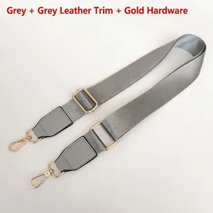 Detail of adjustable gray nylon strap with gold metal hooks and gray leather accents