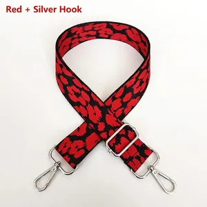 Detail view of red and black leopard print wide bag strap with silver metal swivel hooks