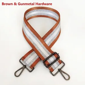 Detail of brown bag strap with silver stripes and gunmetal metal hooks on white background
