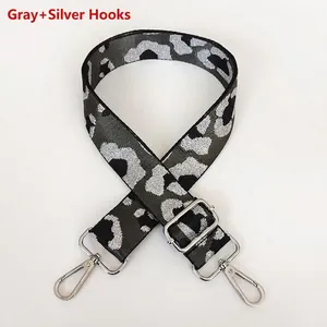 Detail of grey leopard print bag strap with silver metallic threads and swivel hooks