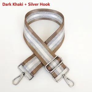 Detail of adjustable khaki bag strap with silver metallic stripes and swivel hooks