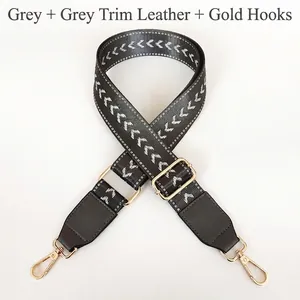 Close-up of grey chevron woven strap with grey leather ends and gold swivel hooks