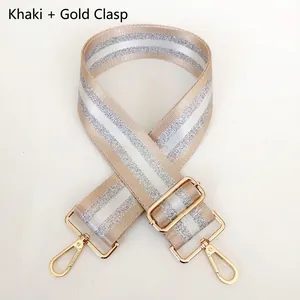 Close-up of khaki wide fabric strap with silver stripes and golden metal rotating hooks