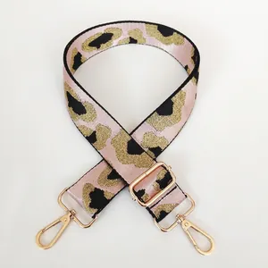 Detail of adjustable leopard print bag strap with pink fabric and gold metal hardware