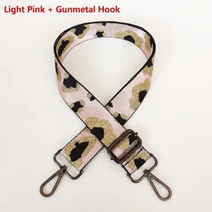 Detail of light pink leopard print wide bag strap with metallic gold and gunmetal hardware