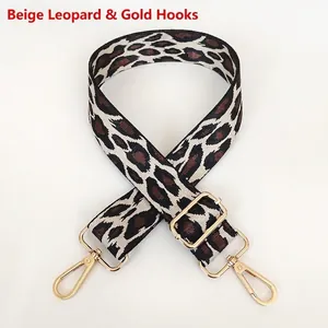 Detail view of leopard print wide replacement strap with gold metal hooks on white background