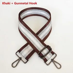 Detail of khaki striped bag strap with glitter accents and gunmetal rotating hooks