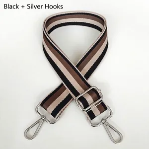 Close-up of black and brown striped adjustable shoulder strap with silver metal hooks