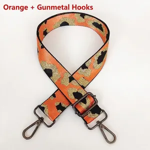 Detail of orange and gold leopard print canvas strap with gunmetal swivel hooks