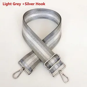 Close-up of adjustable light gray striped shoulder strap with silver metal hooks
