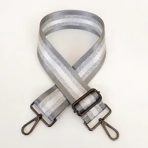 Detail of light grey striped strap with adjustable gunmetal metal hooks and buckle