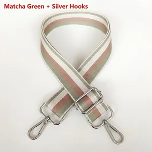 Close-up of matcha green striped woven bag strap with polished silver metal swivel hooks