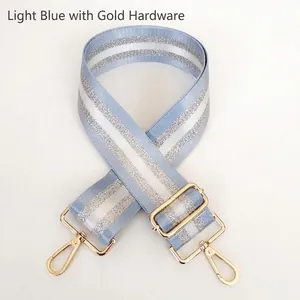 Detail of light blue strap with silver stripes and golden metal swivel hooks