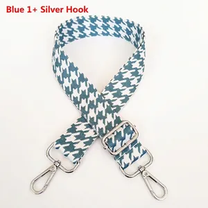 Detail of blue houndstooth wide bag strap with polished silver lobster claw metal clasps