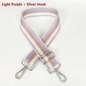 Detailed view of adjustable striped wide shoulder strap with silver metal swivel hooks
