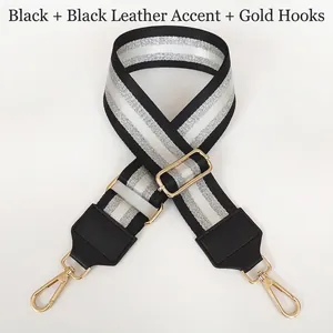 Detail of adjustable black and silver striped nylon bag strap with gold metal hooks