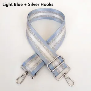 Close-up of light blue adjustable bag strap with silver glitter stripes and metal hooks