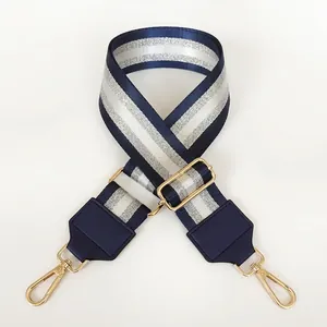 Adjustable blue and white striped nylon bag strap with gold metal hooks and leather ends