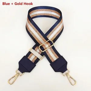 Close-up of adjustable striped nylon bag strap with gold hooks and blue leather ends