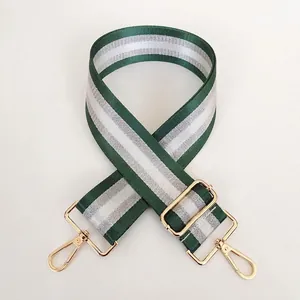 Macro shot of green and white striped bag strap with durable gold metal swivel hooks