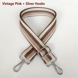 Detail of retro pink striped shoulder strap with adjustable length and silver metal hooks