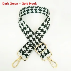 Detail of adjustable dark green houndstooth woven shoulder strap with gold swivel hooks