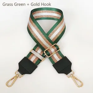 Detail of green striped nylon strap with gold hooks and adjustable metal slider for handbags