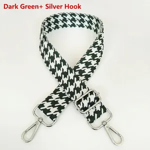 Close-up of dark green houndstooth jacquard shoulder strap with silver metal swivel hooks