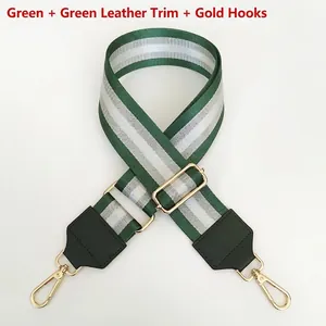 Detail of adjustable green striped nylon bag strap with leather ends and gold metal hooks