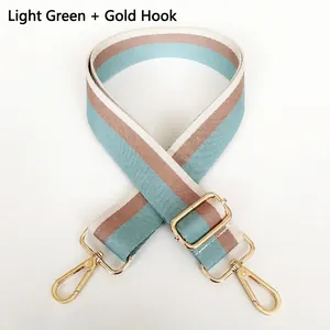 Detail of adjustable light green striped woven strap with gold metal swivel hooks
