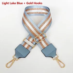 Detail of adjustable light blue and gold woven bag strap with gold metal hardware