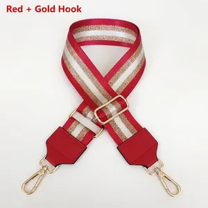 Detail of red and white striped nylon bag strap with polished gold metal hooks