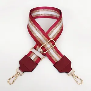Detail of adjustable 5cm nylon bag strap in burgundy and gold glitter stripes