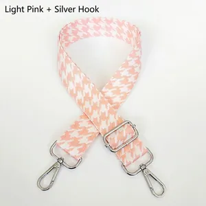 Close-up of light pink houndstooth woven handbag strap with silver metal swivel hooks